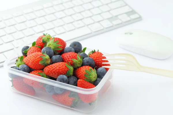 Health lunch with strawberry and blueberry mix in office
