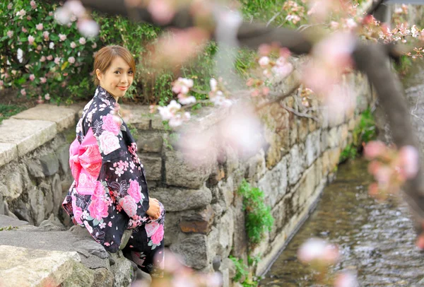 Young woman wearing Japanese kimono with cherry blossom