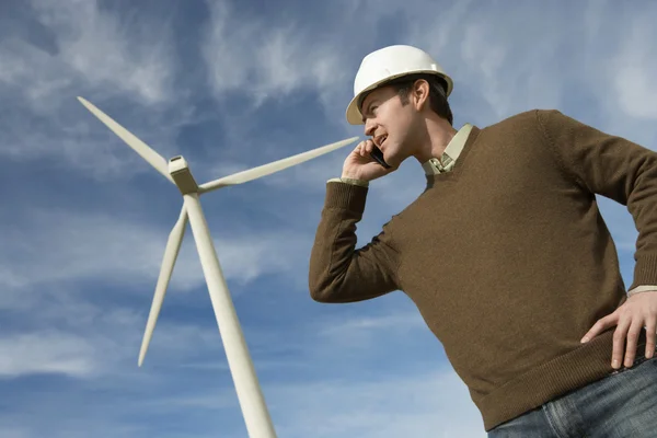Engineer Using Mobile Phone At Wind Farm