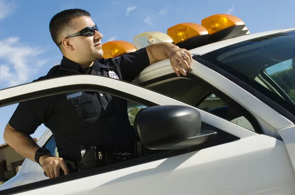Police Officer Leaning On Patrol Car