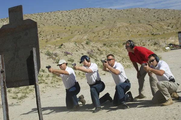Four Firing Guns At Shooting Range