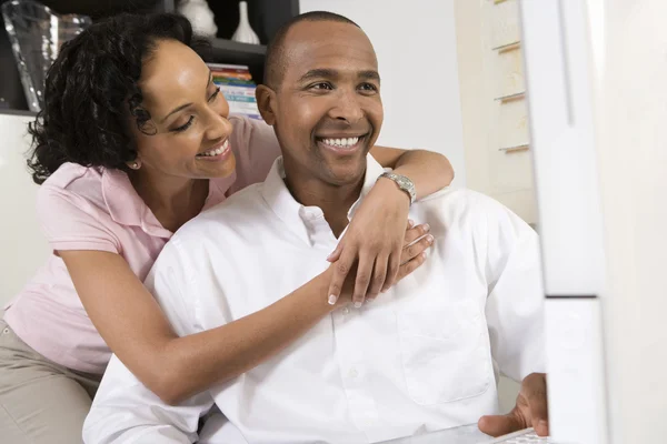 Smiling Couple Using Computer