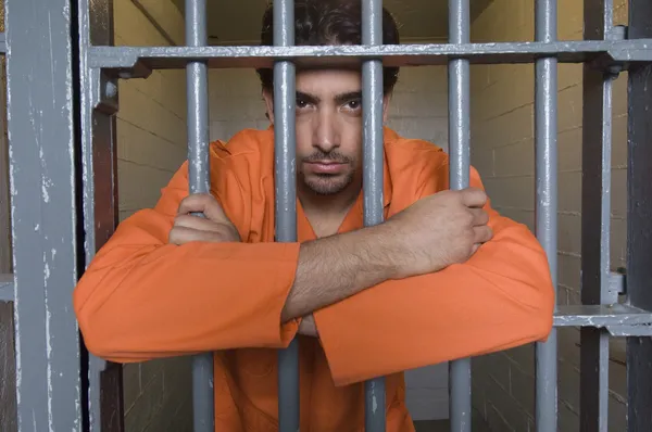 Prisoner Standing Behind Bars