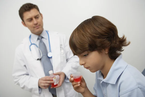 Boy Holding Medicine In Liquid Measure