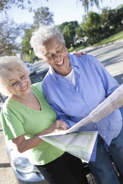 Two Happy Senior Women Reading Map