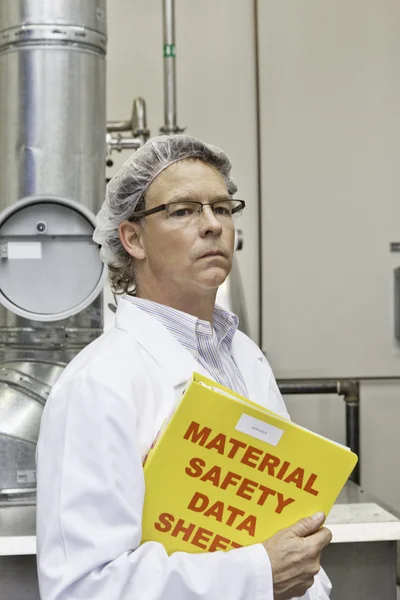 Middle-aged man holding data sheets of factory