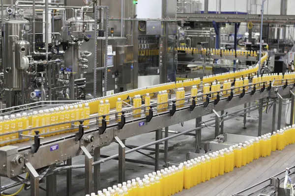 Orange juice bottles on conveyor belt