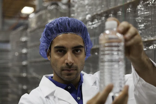 Portrait of factory worker holding water bottle