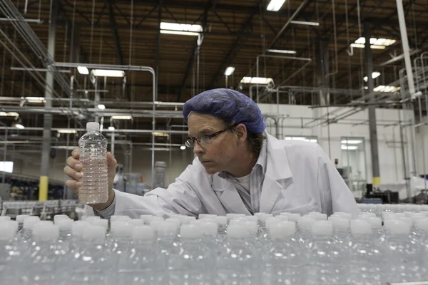 Quality control worker at bottling plant