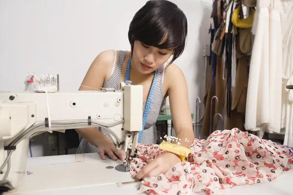 Fashion designer sewing fabric