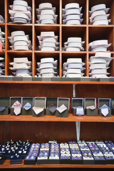 Shirts, neckties and hand cuff links displayed on shelves