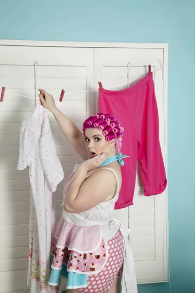 Portrait of a shocked plus-size woman drying clothes