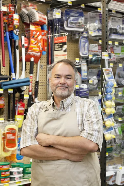 Portrait of a confident mature store clerk with arms crossed in hardware shop