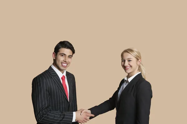 Portrait of young business shaking hands over colored background