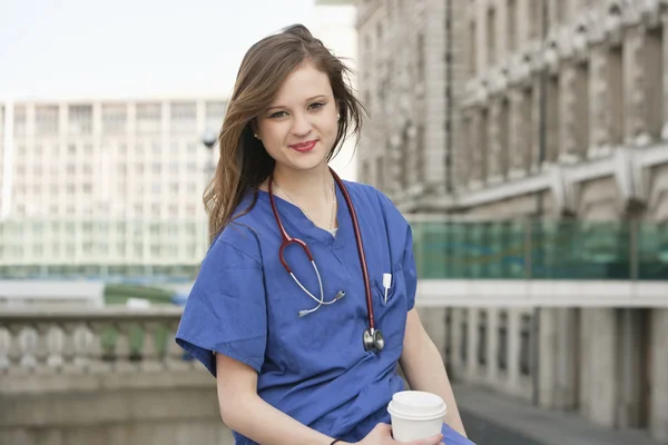 Portrait of a beautiful young female doctor having a coffee break