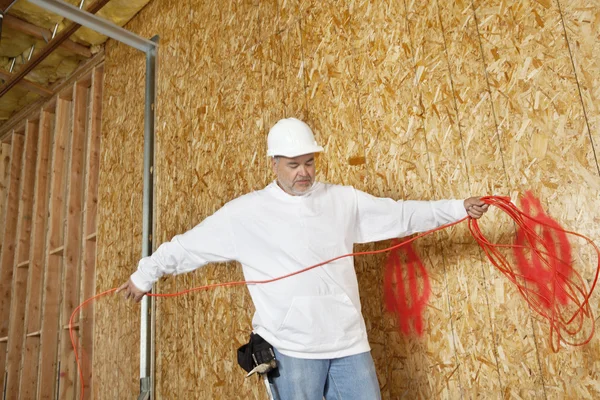 Mature male construction worker with an electrical wire