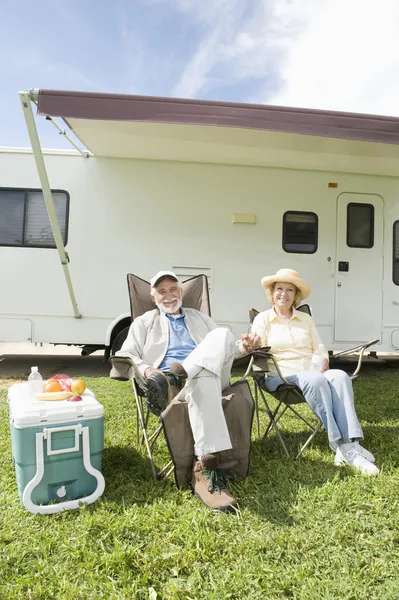 Senior Couple Sit Outside RV Home