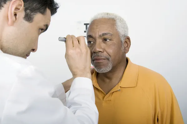 Doctor Testing Patient's Eye At Clinic