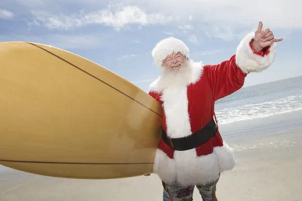 Santa Claus With Surf Board On Beach