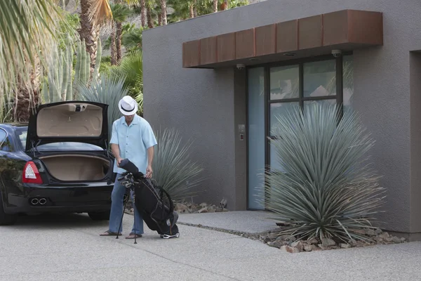 Man With Golf Bag Outside House