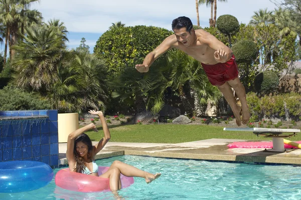 Man Jumping Into Swimming Pool Over Woman On Ring