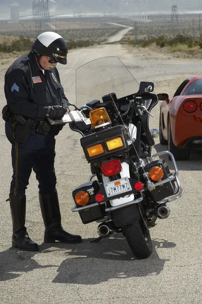 Traffic Cop Writing Against Motorcycle