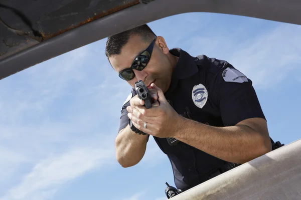 Police Officer Aiming Gun Through Car Window