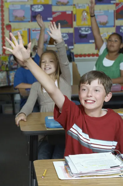 Students Raising Hands In Classroom