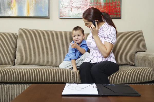 Businesswoman Looking At Son While On Call