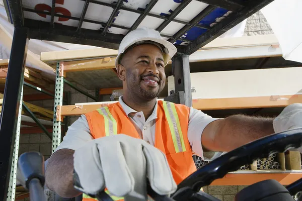 Industrial Worker Driving Forklift At Workplace