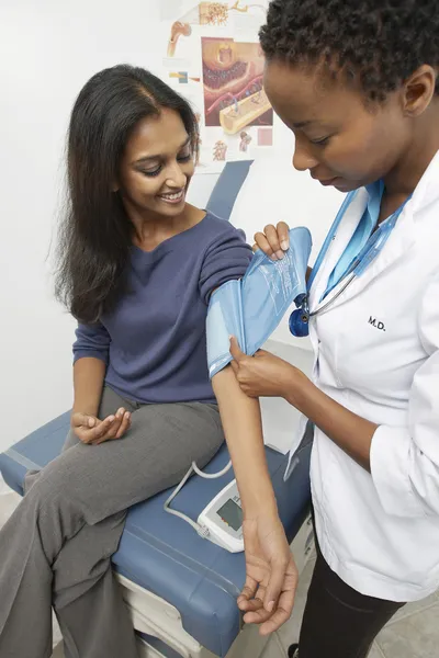 Doctor checking patient blood pressure