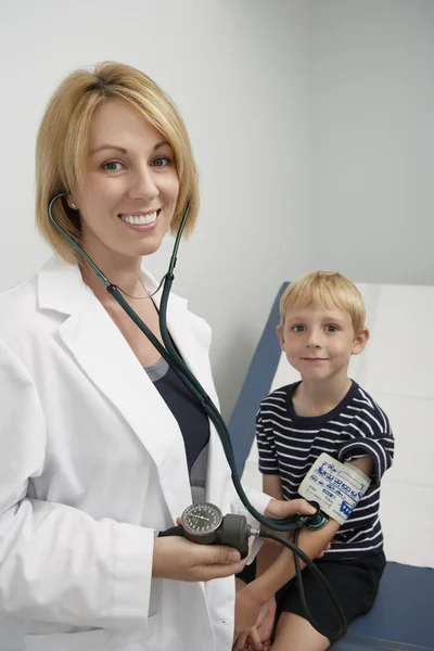 Female Doctor Checking Boy's Blood Pressure