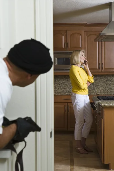 Burglar With Gun Peeking At Woman