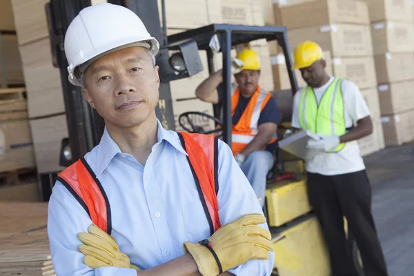 Portrait of a man in front of two workers