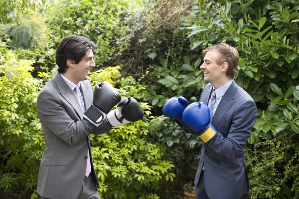 Two young men in suits stage a mock boxing match