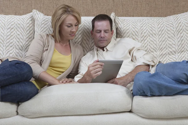 Couple On Sofa With Digital Tablet At Home