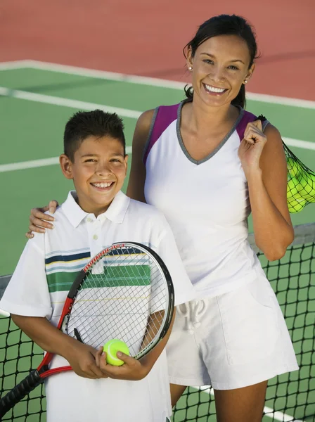 Mother and son on tennis court