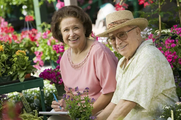 Senior Couple sitting among flowers