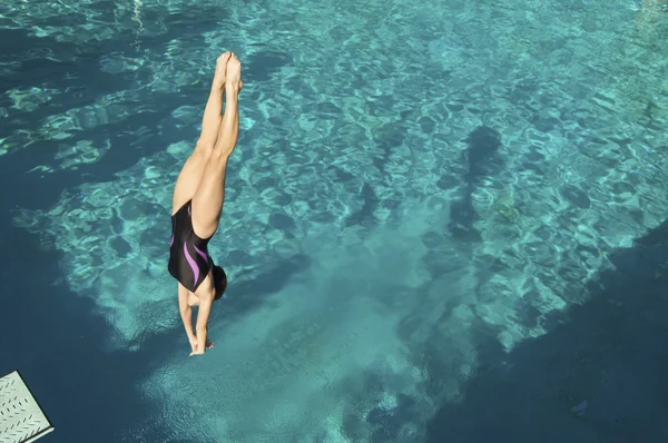 Female diver diving in pool