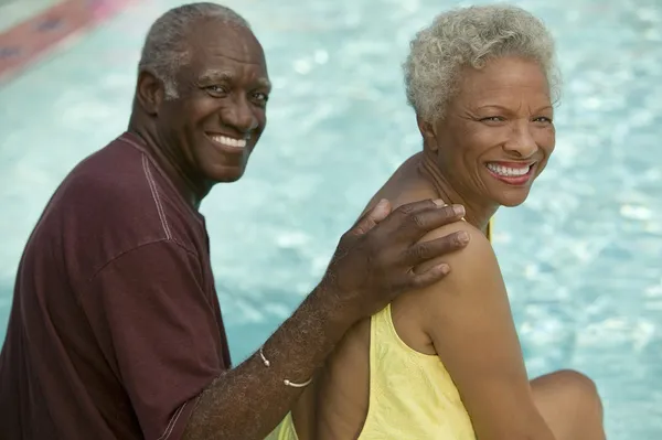 Senior Couple sitting by swimming pool