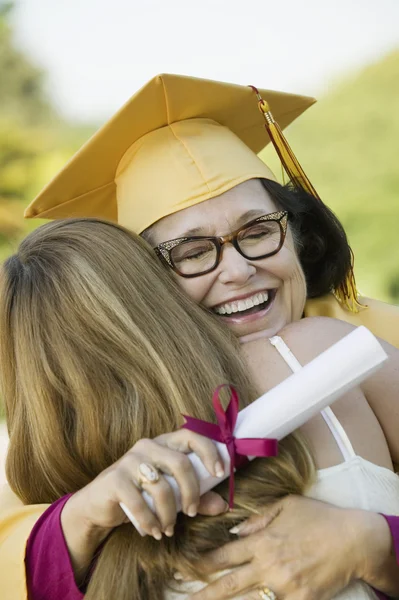 Graduate hugging daughter
