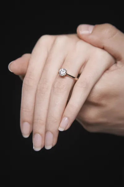 Woman\'s hand displaying engagement ring