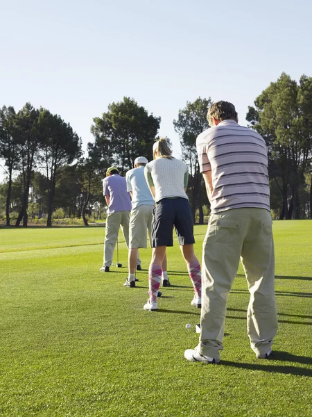 Young golfers in row