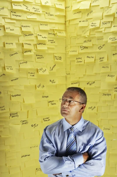 Man in front of wall covered in sticky notes