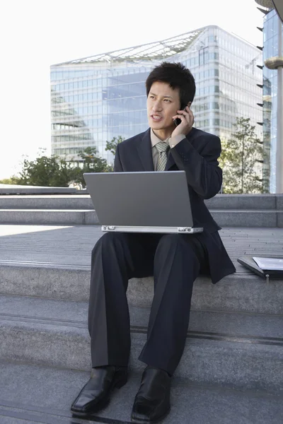 Businessman on outdoor Steps Using Laptop