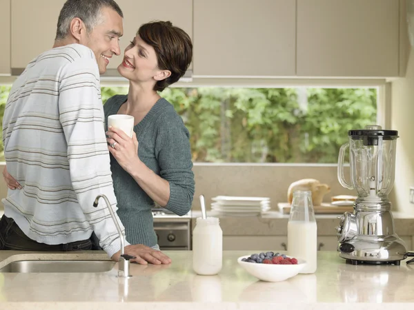 Smiling couple flirting in kitchen