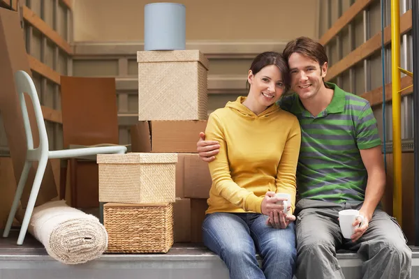 Couple Sitting in Back of Moving Van