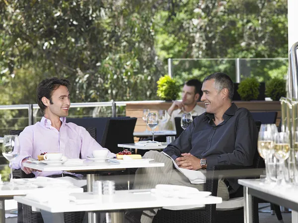 Two men talking at cafe