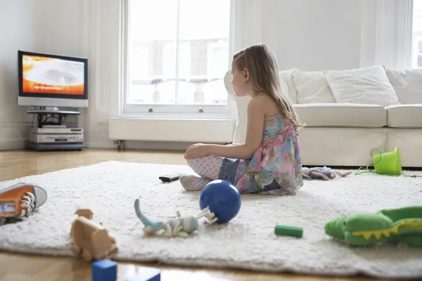 Girl sitting on floor watching television