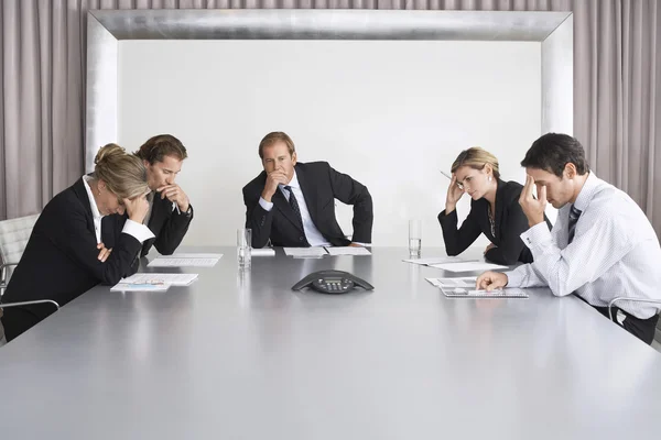 Frustrated Businesspeople Listening to Conference Call